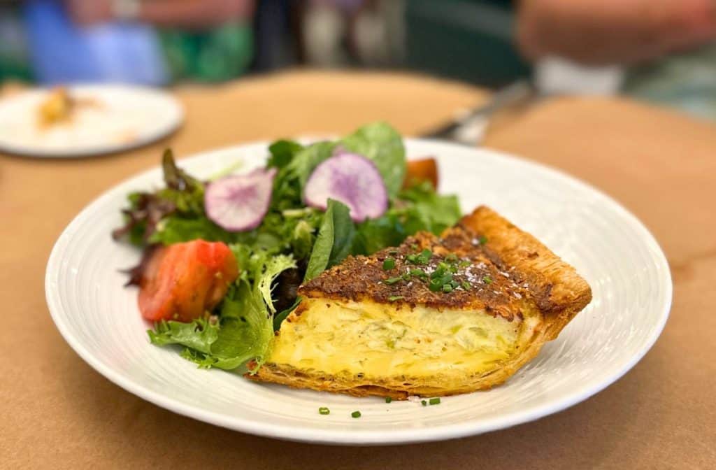 Beautiful quiche with greens on the plate