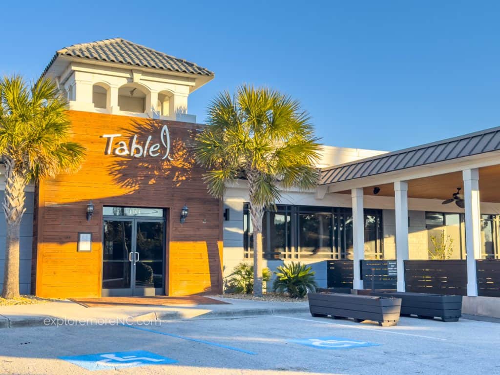 The modern exterior of Table 9 restaurant, featuring a wooden facade with the establishment's name prominently displayed above the entrance.